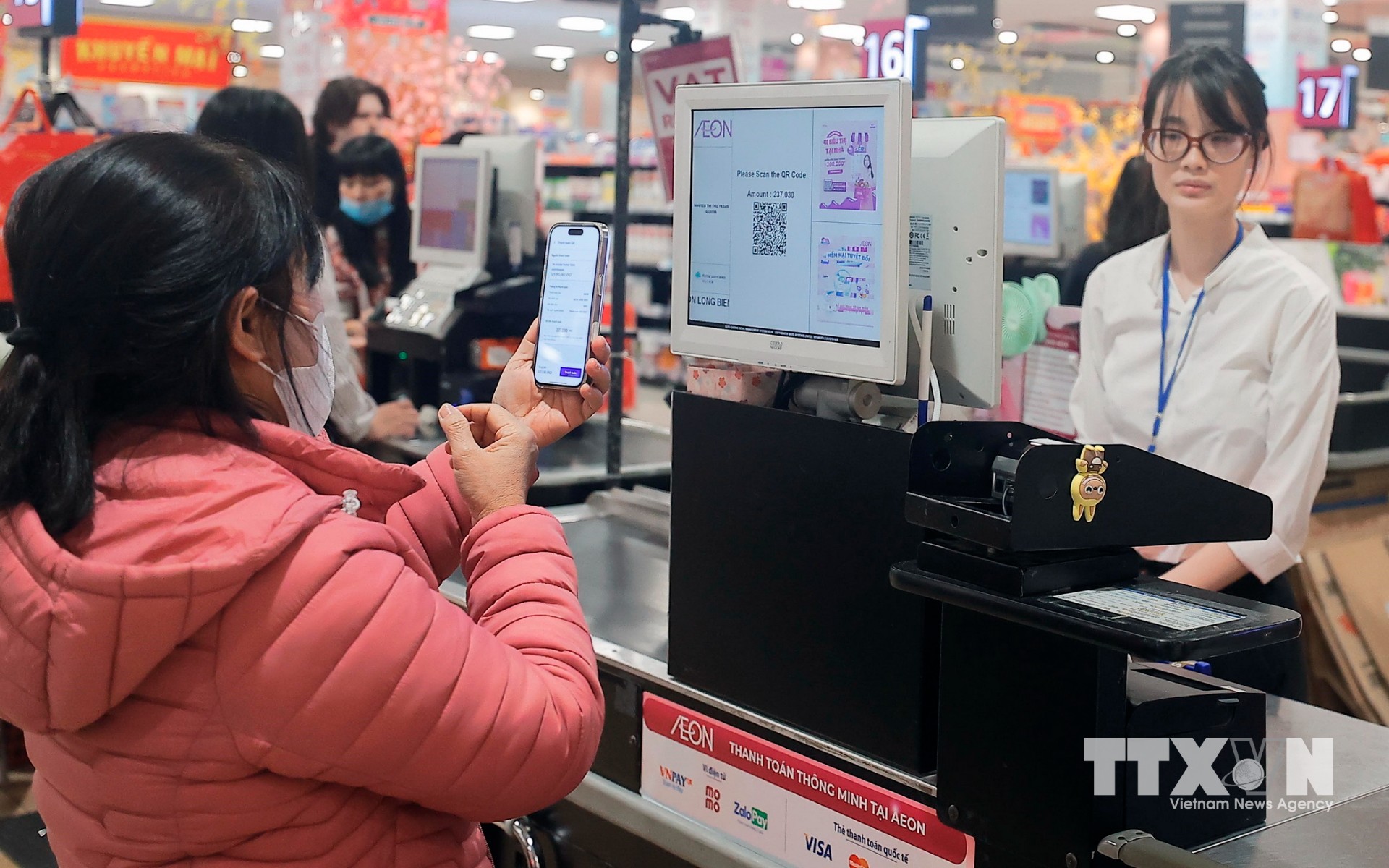 Khách hàng quét mã QR Code thanh toán không dùng tiền mặt tại siêu thị AEON Long Biên (Hà Nội). (Ảnh: Trần Việt/ TTXVN)